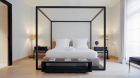 See more information about La Réserve Apartments Paris bedroom with four post bed