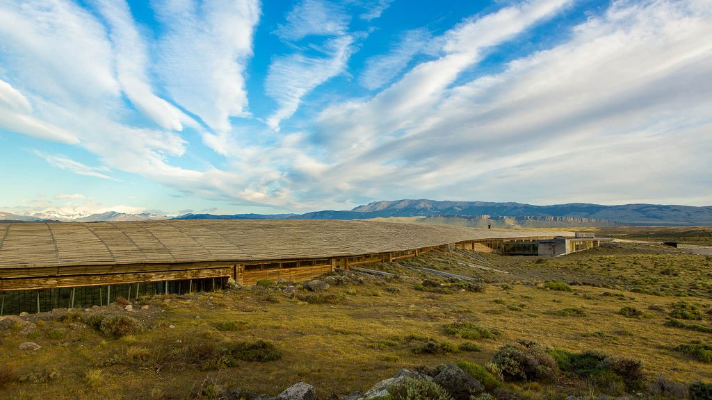 Tierra Patagonia Hotel curved architecture blending into the landscape with Torres del Paine massif in the background Chile