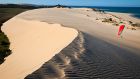 beach sand dunes with kite surfer anantara bazaruto island resort and spa