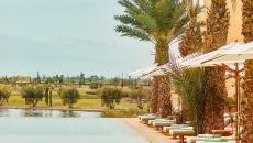 main pool atlas golf view sky horizon lounge chair parasol palm vegetation sun day at Park Hyatt Marrakech