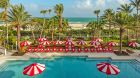 Pool with red umbrellas and ocean views