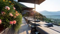 sun loungers with flowers behind at Hotel AVIDEA